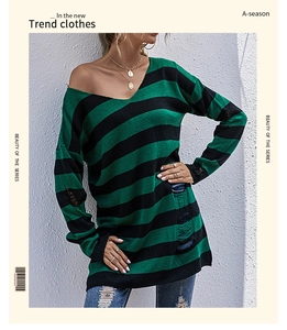 Detail of green and black striped knit sweater showing distressed ripped texture