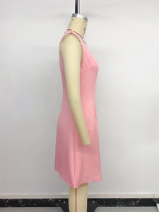 Side view of a sleeveless pink crew neck A-line dress on a mannequin with pearl necklace