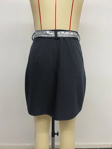 Dettaglio di una gonna a matita vintage blu navy con cintura decorativa motivo paisley