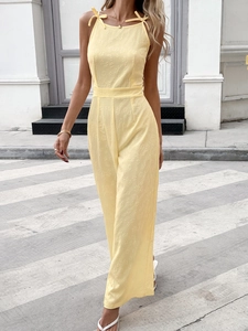 Detail of light yellow sleeveless jumpsuit with tie-shoulder straps and jacquard texture