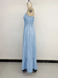 Detail of light blue strapless dress featuring smocked high waist and layered tiered skirt