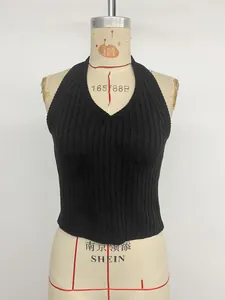 Detail of black ribbed knit texture and deep V-neck design on halter top