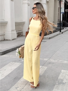 Detail of light yellow jacquard sleeveless jumpsuit with bow ties and wide leg design