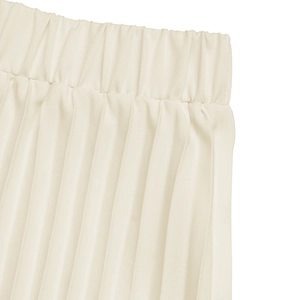 Close-up of pleated cream skirt with high elastic waist and textured fabric detail