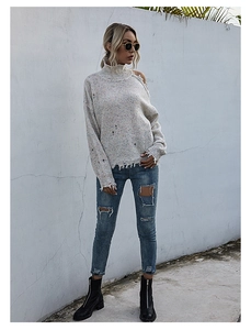 Chic off-shoulder distressed beige speckled knit sweater styled with ripped denim jeans
