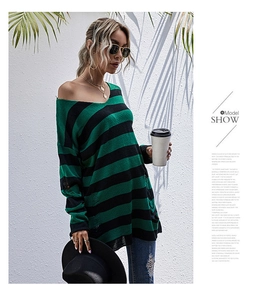 Detail view of green and black striped knit sweater featuring distressed ripped hem and cuffs