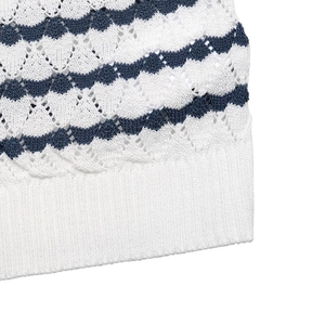 Close-up of pointelle knit fabric with wavy stripes and white ribbed hem on a short sleeve top