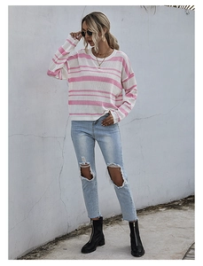 Detailed view of pink and white striped knit texture on a loose long sleeve sweater