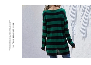 Detail view of a loose green and black striped knit sweater back with binding collar