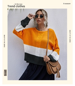 Détail d'un pull en maille torsadée pour femme avec blocs de couleurs orange et vert