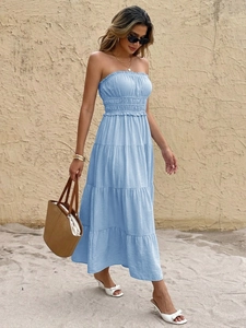 Close-up of smocked tube top and tiered skirt design on light blue summer maxi dress