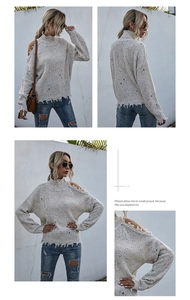 Detail of off-shoulder cable knit sweater with distressed edges and ripped textures