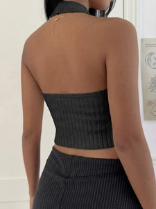 Detailed back view of a black halter neck knit top with fine ribbed texture and open back