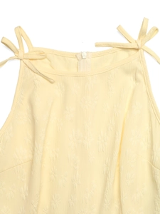 Detail of floral jacquard texture on yellow jumpsuit with tie straps and SBS zipper