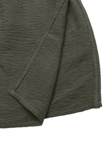 Detailed close-up of dark olive green fabric texture with neat stitching and seam finish