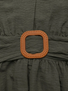 Detail of elegant dark green dress waist with a textured amber rectangle buckle detail
