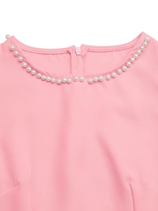 Detail of elegant round neckline with white faux pearls and back zipper on pink dress
