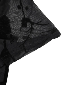 Detail of black sheer mesh fabric with elegant floral velvet flocking and embroidery