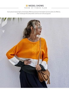 Détail d'un pull en maille color-block avec rayures texturées orange, blanc et gris