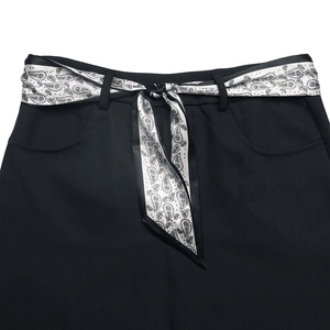Dettaglio gonna nera retrò con cintura paisley e tasche laterali simmetriche