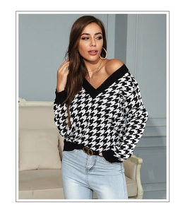 Close-up of black and white houndstooth knit sweater with elegant V-neckline detail
