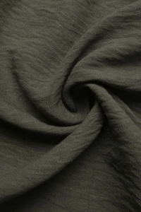 Detail of dark olive green fabric texture with natural weave patterns and soft folds