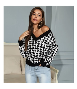 Detailed close-up of V-neckline and houndstooth pattern on black and white knitted sweater