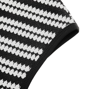 Close-up of knit fabric detail featuring black and white wave patterns with neat edge stitching
