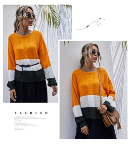 Détail d'un pull en maille color-block avec motif losanges et poignets côtelés