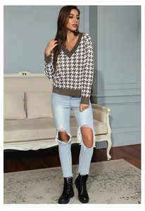 Detailed view of women V-neck houndstooth knit sweater with ripped jeans and boots