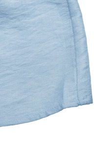 Detailed close-up of light blue fabric hem with professional stitching on a strapless dress