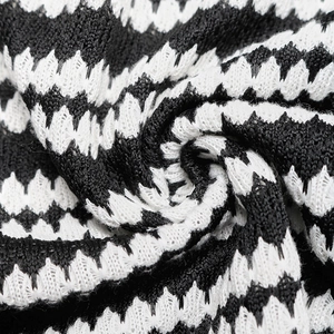 Macro detail of high-quality black and white wave textured knit fabric on maxi dress