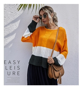 Détail du pull en tricot color-block avec poignets côtelés en orange, blanc et vert