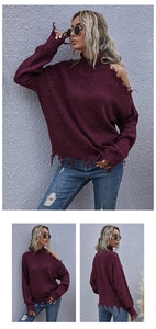 Macro view of burgundy confetti knit sweater with cold shoulder and frayed hem detail
