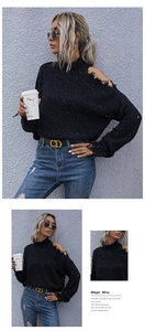 Detail of black speckled knit sweater featuring a chic cutout shoulder and mock neck design