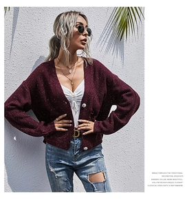 Detaillierte Textur der burgunderroten Strickjacke mit bunten Punkten und Knöpfen