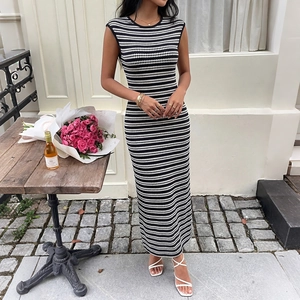 Sleeveless black and white striped bodycon maxi dress in a summery outdoor setting