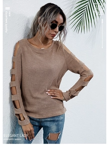 Detail of khaki ribbed knit top with cold shoulder cutouts and multi-section sleeve design