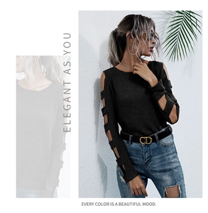 Detail of black knit top featuring stylish cut-out shoulder and hollow sleeve design