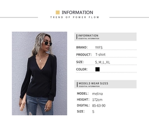 Detail of black V-neck ribbed wrap top with slim fit long sleeves and textured fabric