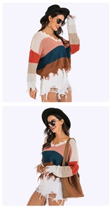 Detail of color-block V-neck sweater with distressed ripped edges and fringe hem