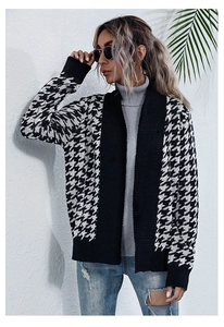 Detail of V-neck houndstooth knit cardigan with black ribbed edges and waist tie