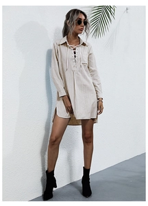Detail of blue striped shirt dress featuring a V-neck lace-up collar and front pocket