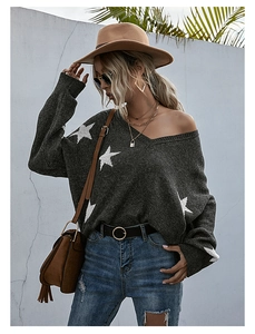 Detail of V-neck loose knit sweater with star jacquard patterns and chic distressed hem