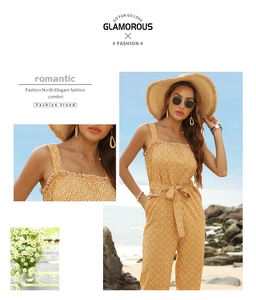 Detail of yellow floral jumpsuit with ruffle neckline and tie waist on beach
