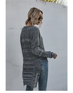 Detail of grey oversized knit sweater with distressed ripped edges and long fringe tassels