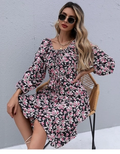 Detail of square neckline with tie and pink floral pattern on black long sleeve dress