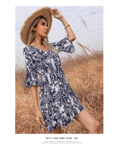 Detail of V-neckline and tropical leaf print on a navy blue flare sleeve mini dress