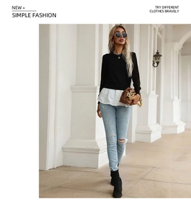 Detail of a black knit sweater featuring a white shirt hem for a layered, two-piece aesthetic