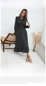 Détail de l'encolure en V avec laçage et motif à pois sur une robe noire à manches longues